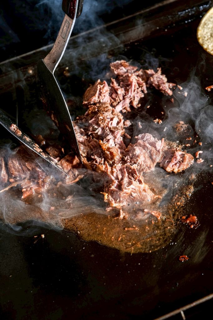 注文ごとに鉄板で焼き上げ — ヘラで刻みながら仕上げる